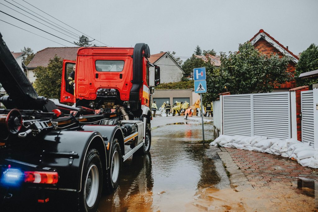 Emergency vehicles and personnel addressing urban flooding caused by heavy rains.