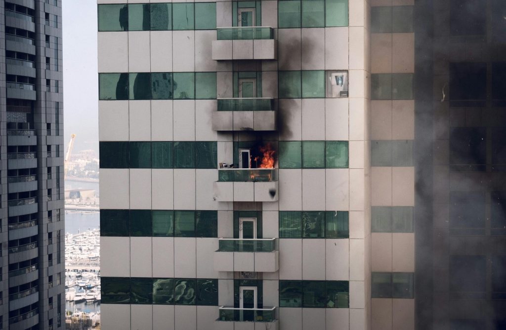 Burning apartment with smoke damage on facade in Dubai Marina. Urban disaster scene captured outdoors.