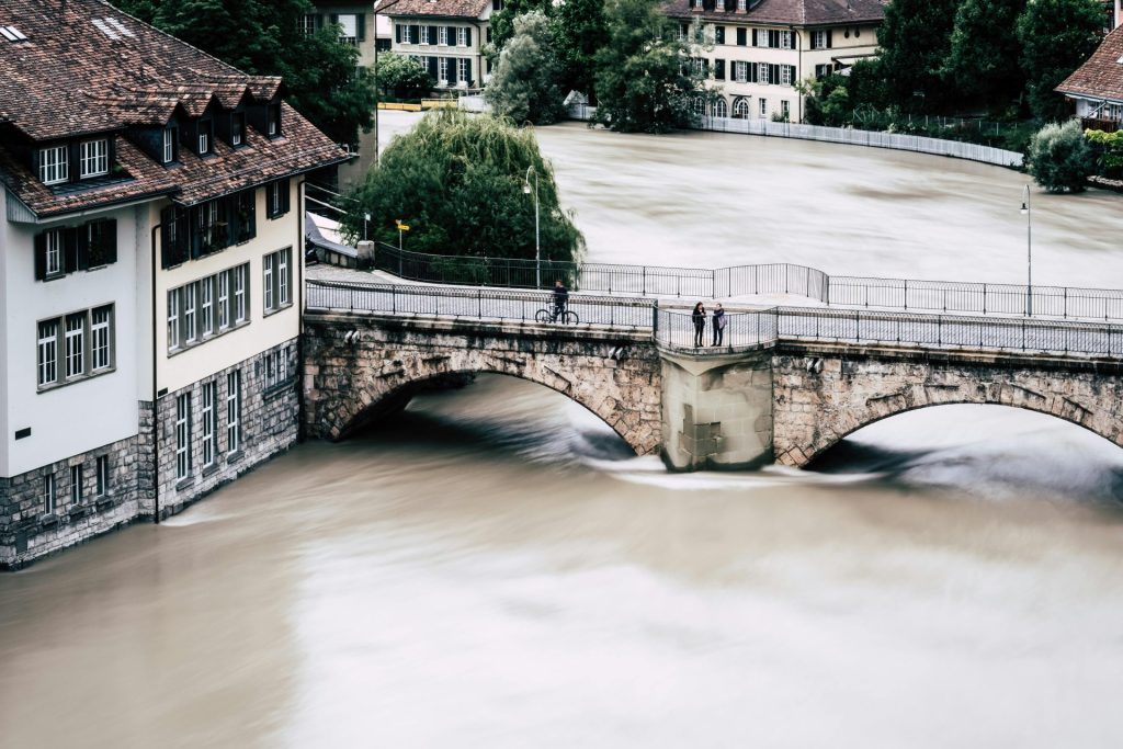 Aerial view of a historic bridge over a flooded river in Bern, Switzerland.
