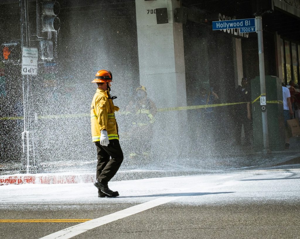 man standing near road beside Hollywood building